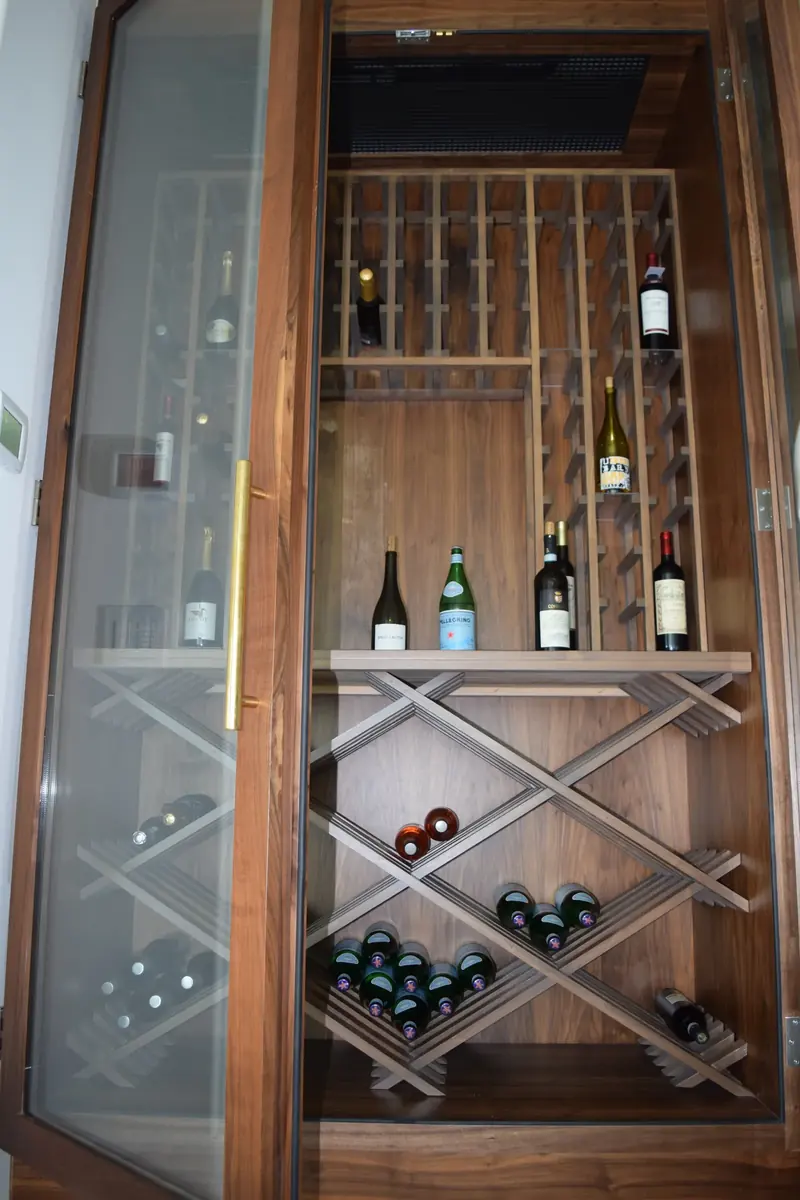 Walnut wine cabinet with lattice bottle storage and a glass door