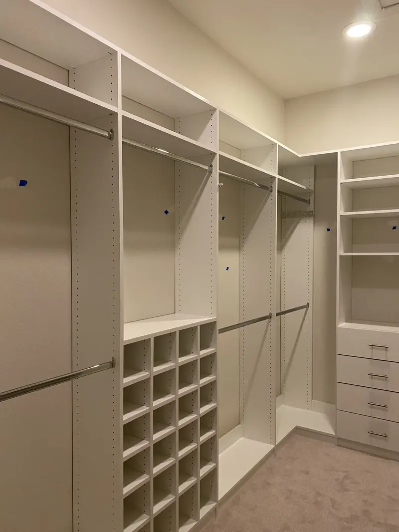 Custom walk-in closet with shoe cubbies, hanging rods and drawers