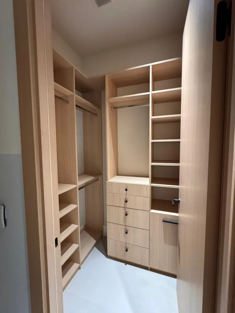 White oak walk-in closet with drawers, shelves and hanging rods by Eco Woodwork & Design