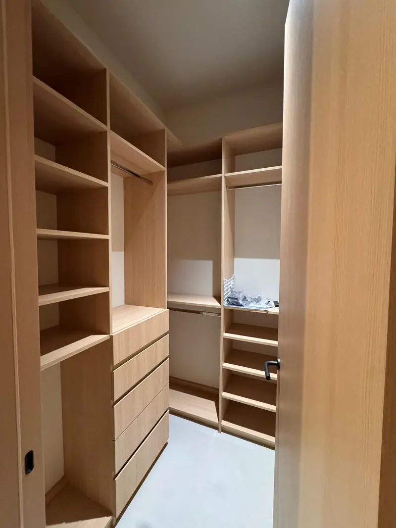 White oak reach-in closet with open shelving and drawers by Eco Woodwork & Design