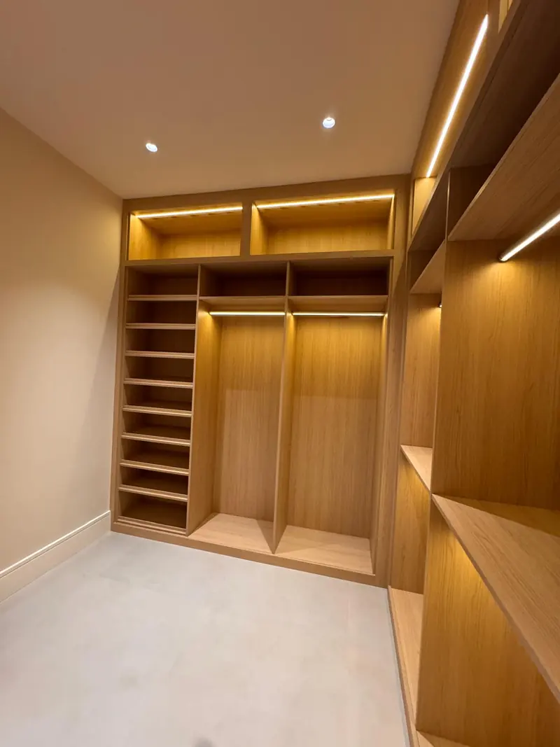 White oak closet with LED-lit shelving and hanging sections by Eco Woodwork & Design