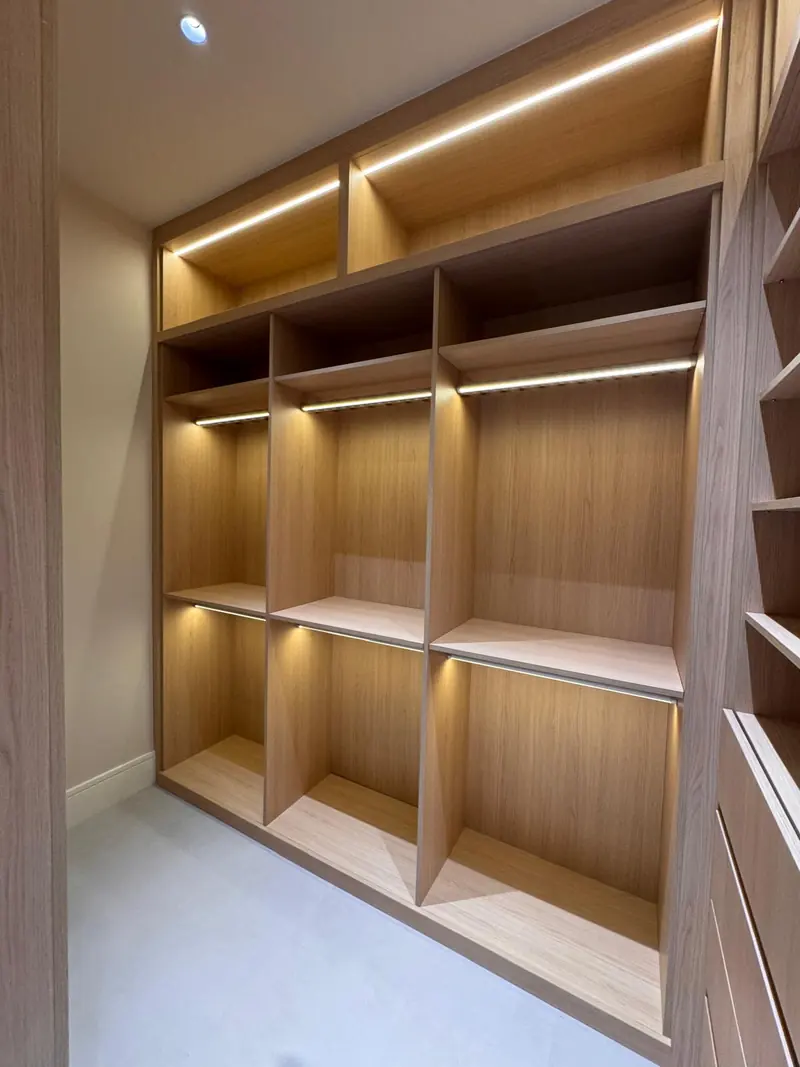 White oak closet shelving with integrated lighting by Eco Woodwork & Design
