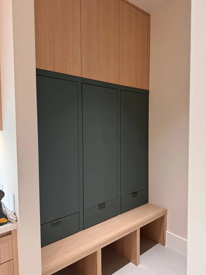 Mudroom with green lockers and a white oak bench by Eco Woodwork & Design