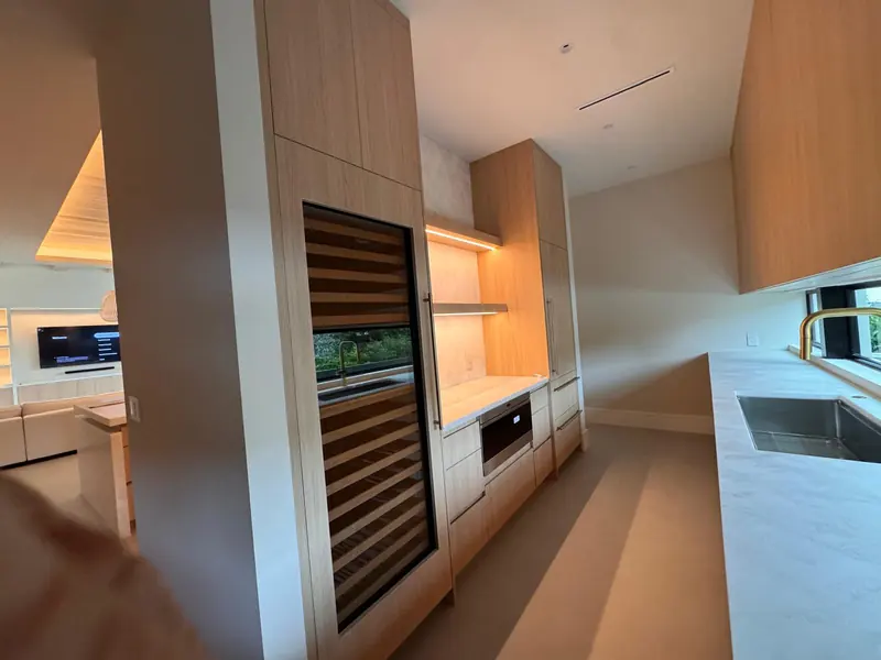 White oak kitchen with a built-in wine column and backlit shelving by Eco Woodwork & Design