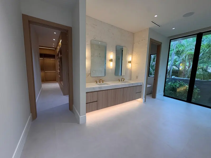 Floating white oak double vanity with under-cabinet lighting by Eco Woodwork & Design