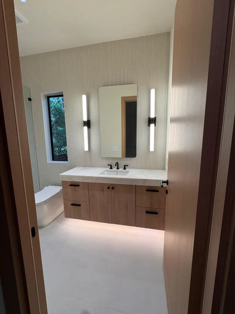 Floating white oak bathroom vanity with backlit mirror by Eco Woodwork & Design