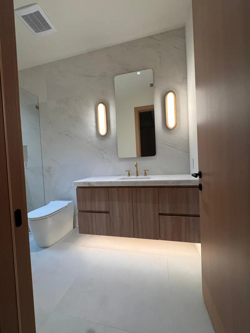 Floating white oak vanity with under-glow lighting by Eco Woodwork & Design