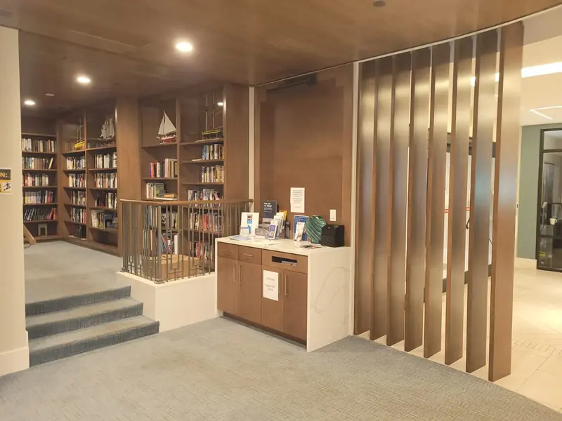 Custom wood library with built-in shelving and a slatted wood divider