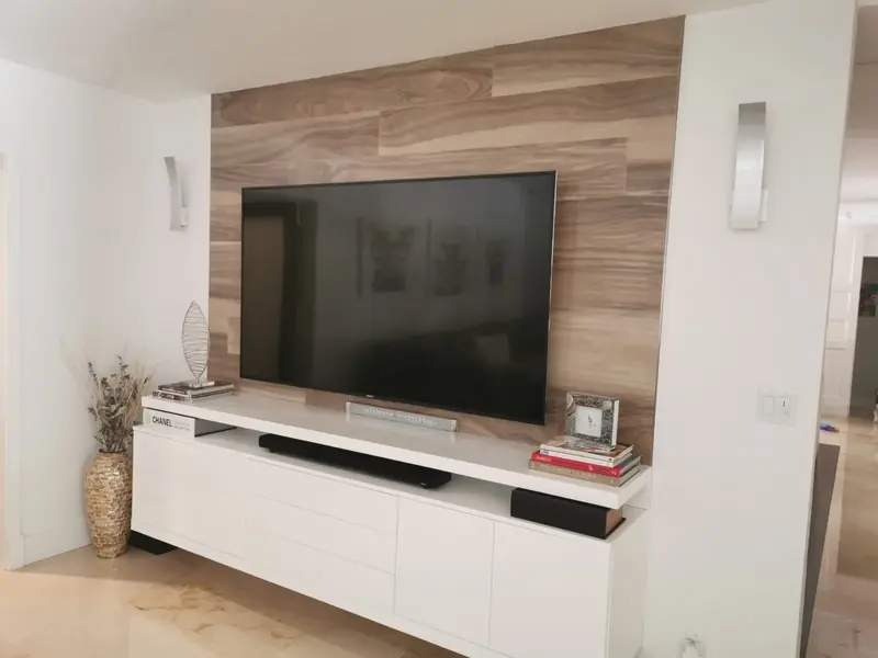 Living room media wall with a wood-plank feature panel and white base cabinets