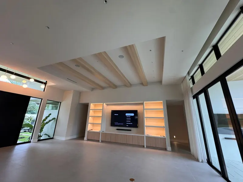 Living room media wall with lit white oak shelving by Eco Woodwork & Design
